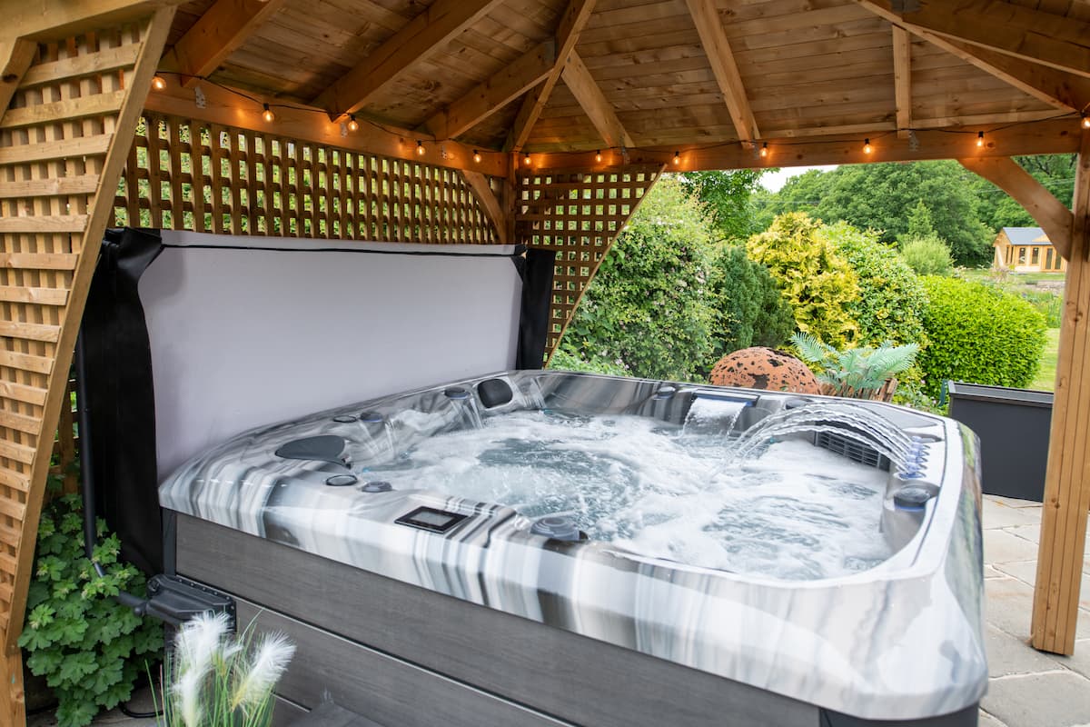The Barcelona hot tub from Platinum Spas with its jets flowing under a canopy.