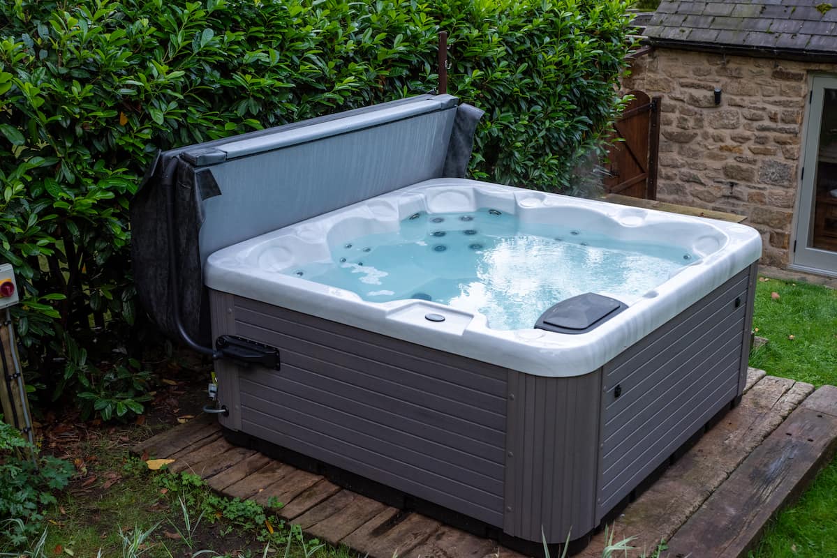 A Platinum Spas hot tub on raised decking in a home’s garden.