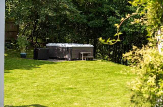 A Tokyo hot tub in a secluded garden, under dappled sunlight.