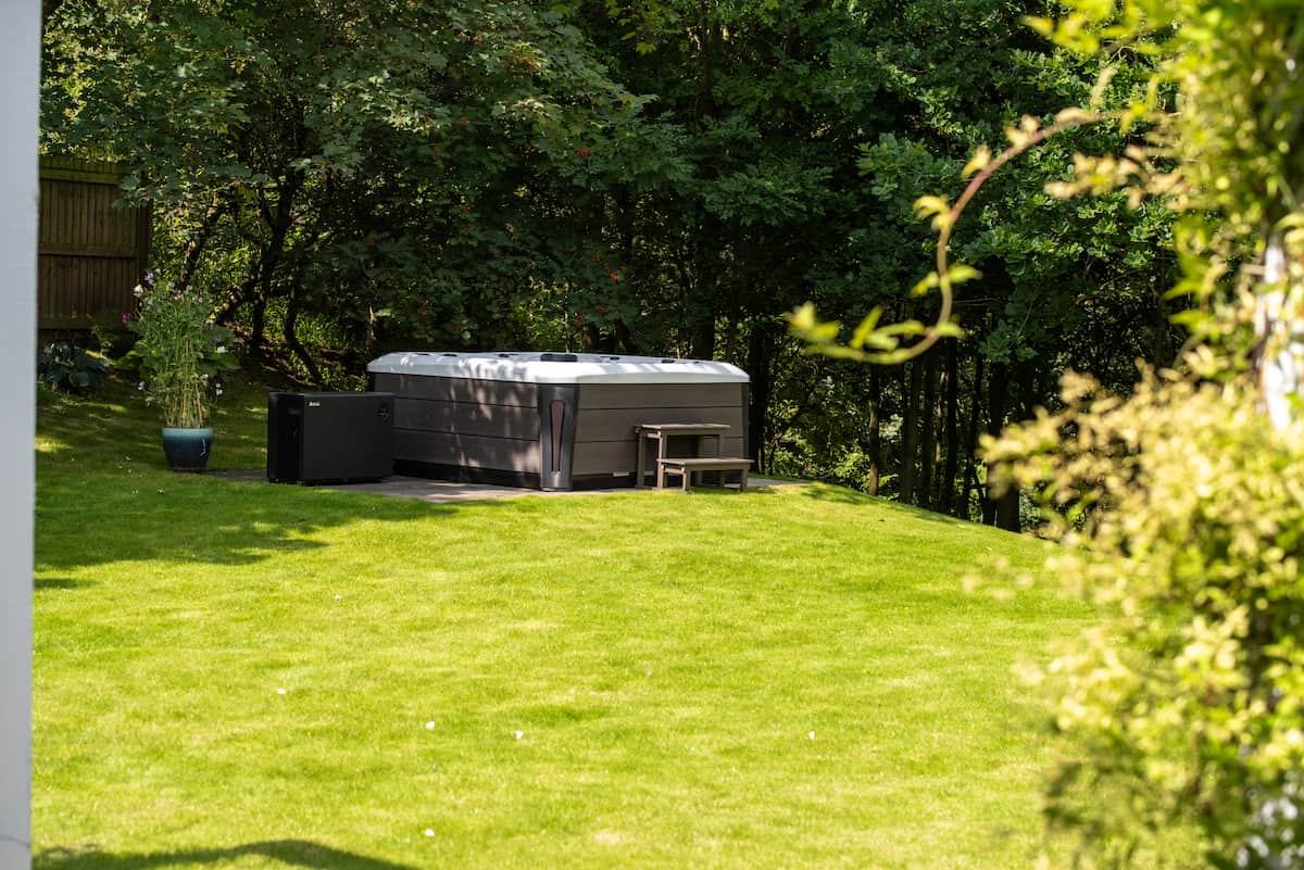 A Tokyo hot tub in a secluded garden, under dappled sunlight.
