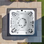 Overhead view of a Platinum Spas Colombo hot tub on a paved patio next to a lawn
