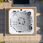 Overhead view of a Platinum Spas Kenya hot tub built into a timber deck surround on a paved patio