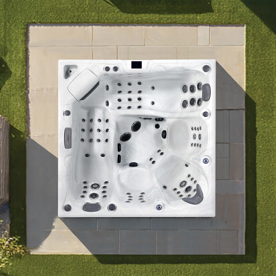 Overhead view of a Platinum Spas Onyx hot tub on a paved patio, showing the jet layout and two loungers