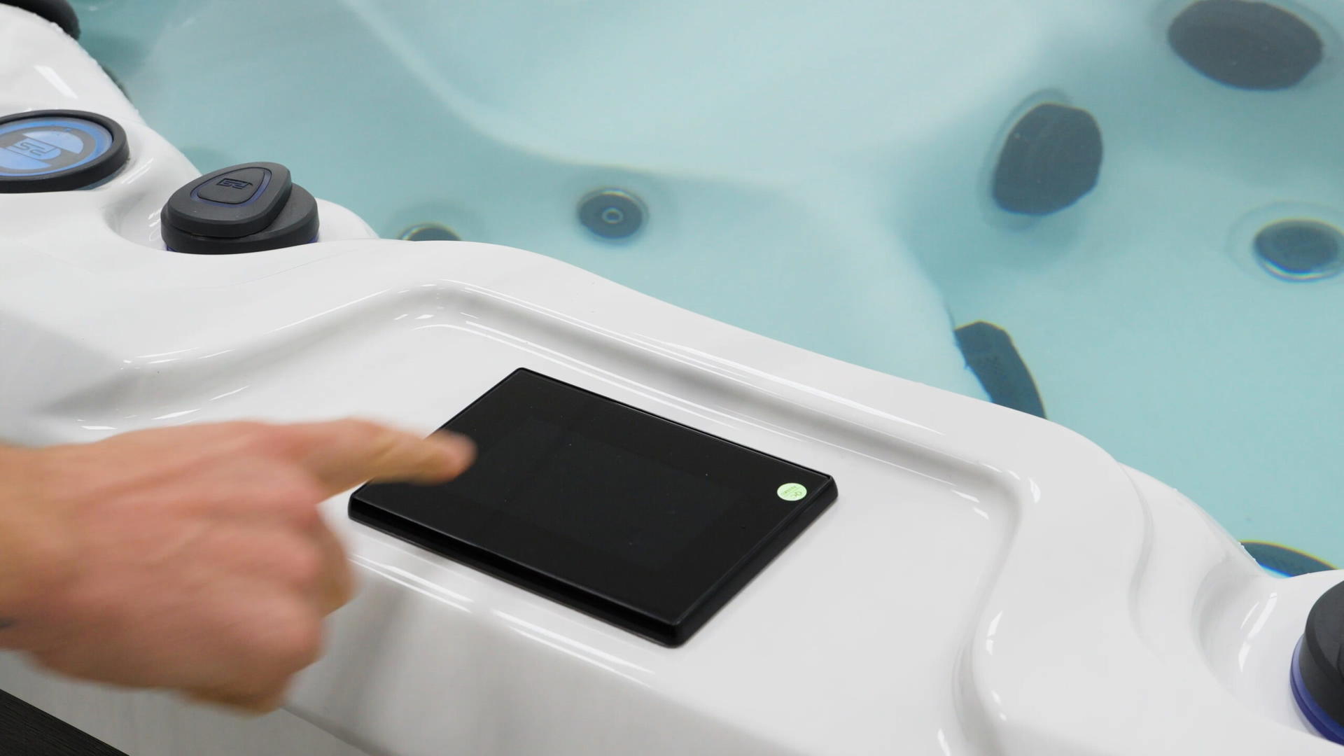 Finger reaching for the SpaTouch touchscreen control panel on a Platinum Spas hot tub