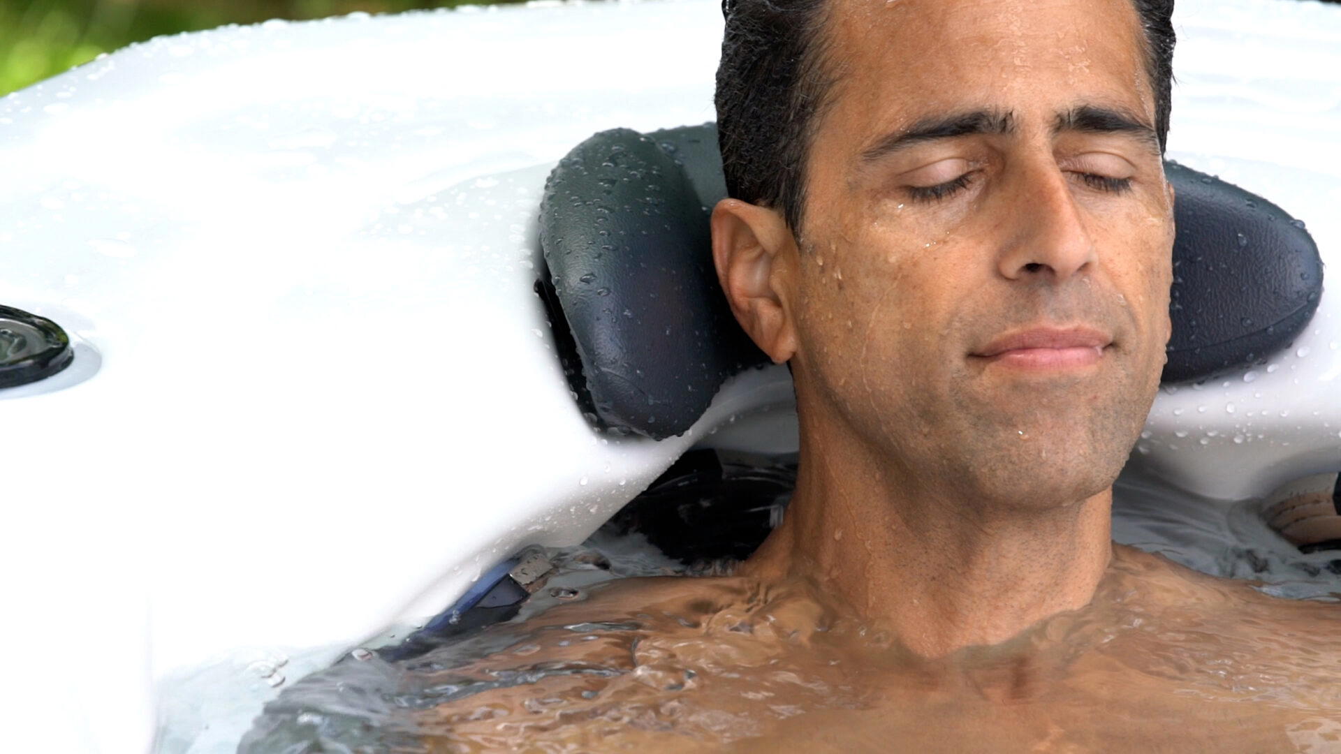 Homme se détendant contre l’appui-tête d’un spa Platinum Spas Portofino