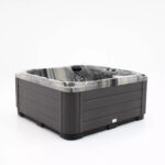 Platinum Spas Refresh hot tub in dark marbled acrylic with a charcoal cabinet, three-quarter angle view