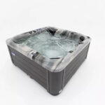 Platinum Spas Refresh hot tub filled and running, showing bubbling jets and blue LED lighting