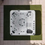 Overhead view of a Platinum Spas Refresh hot tub on a paved patio, showing the seat and jet layout