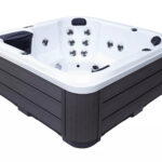Platinum Spas Reims hot tub corner view showing seat layout, jets and dark wood-effect cabinet paneling
