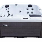 Platinum Spas Reims hot tub in white acrylic with a dark wood-effect cabinet, front view on a plain background