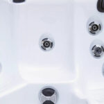 Hydrotherapy jets in a seat of a Platinum Spas Reims hot tub, positioned for muscle relief