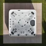 Overhead view of a Platinum Spas Seville hot tub on a paved patio, showing all seven seats and control panel