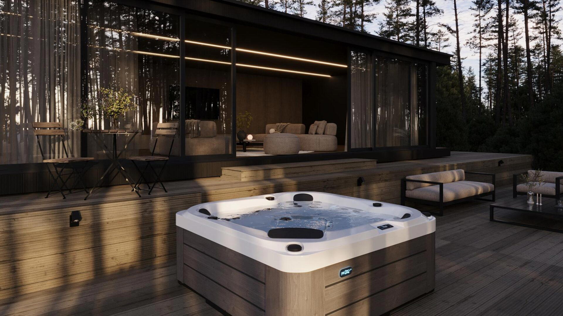 Platinum Spas St Tropez hot tub on a wooden deck beside a modern glass-fronted cabin in daylight