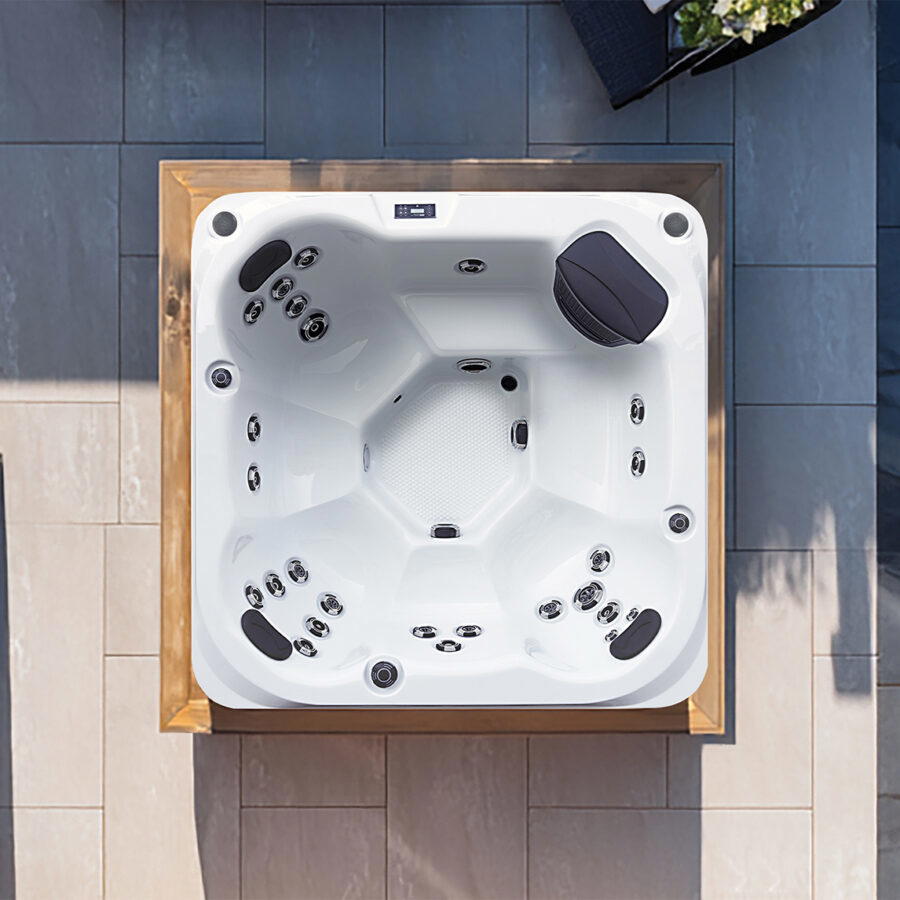 Overhead view of a Platinum Spas St Tropez hot tub on a paved patio, showing the seat layout and jets