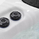 Platinum Spas Tahiti hot tub control buttons close up with water droplets on the acrylic