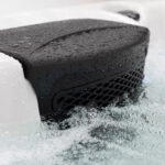 Platinum Spas Tahiti hot tub headrest with hydrotherapy jets and water spraying nearby