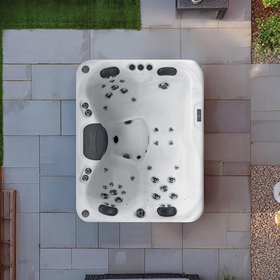 Overhead view of a Platinum Spas Tahiti hot tub on a patio, showing the lounger seat, headrests and jet layout
