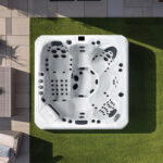 Overhead view of a Platinum Spas Tokyo hot tub on a paved patio, showing the five-seat and lounger layout