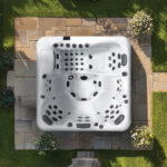 Overhead view of a Platinum Spas Florence hot tub on a stone patio, showing five seats and a full-length lounger