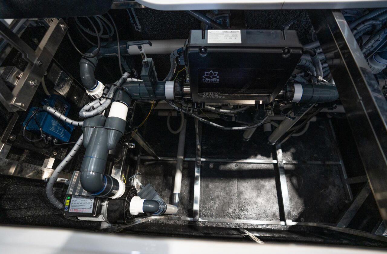 Equipment bay of a Platinum Spas mini pool showing the pumps, pipework and control box