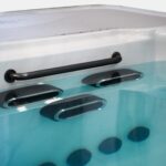 Grab rail above three swim jets in a filled Platinum Spas mini pool