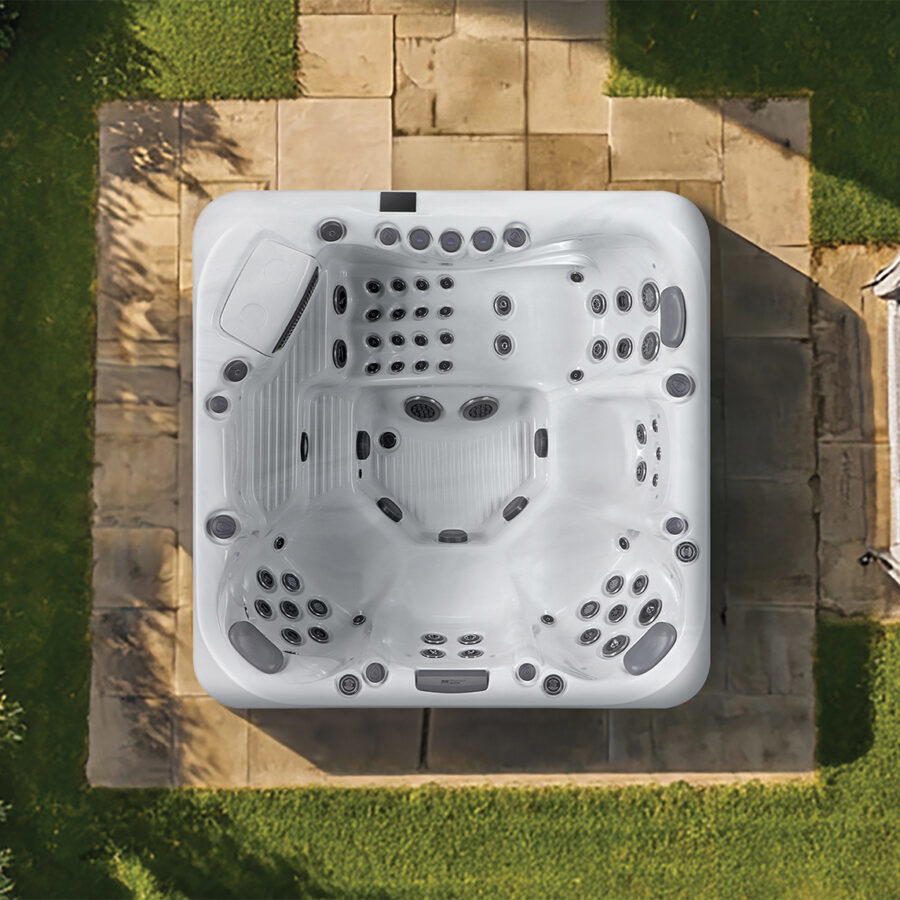 Overhead view of a Platinum Spas Positano hot tub on a paved patio, showing all four seats, the lounger and jet layout