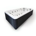 Platinum Spas Titan swim spa shown empty from a close three-quarter studio view with dark cabinet