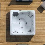 Overhead view of a Platinum Spas Vacation Lounge hot tub on a wooden deck, showing the lounger seat and jets