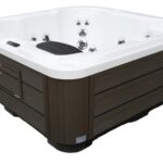 Platinum Spas Vacation Lounge hot tub with cover open, showing the white interior, headrest and jet layout