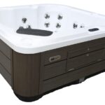 Platinum Spas Vacation Social hot tub corner view, showing the white acrylic shell, headrest, jets and wood-effect cabinet