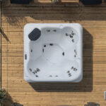 Overhead view of a Platinum Spas Vacation Social hot tub on a wooden deck, showing the jet layout and headrest