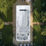 Platinum Spas Zelus Pro swim spa overhead lifestyle composite render in a paved garden setting