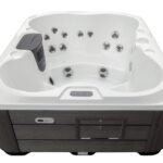 Platinum Spas Vacation Retreat hot tub in Pure White acrylic with grey cabinet, front view showing jets and headrest