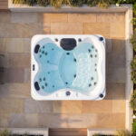 Vue aérienne d’un spa St. Lucia de Platinum Spas sur une terrasse en pierre entourée de plantes en pot