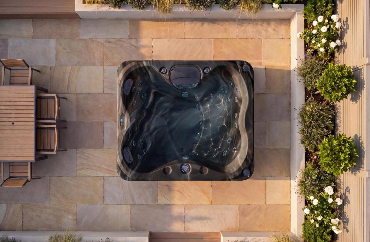Platinum Spas St. Lucia hot tub in Midnight Canyon acrylic, overhead view on a stone patio at dusk