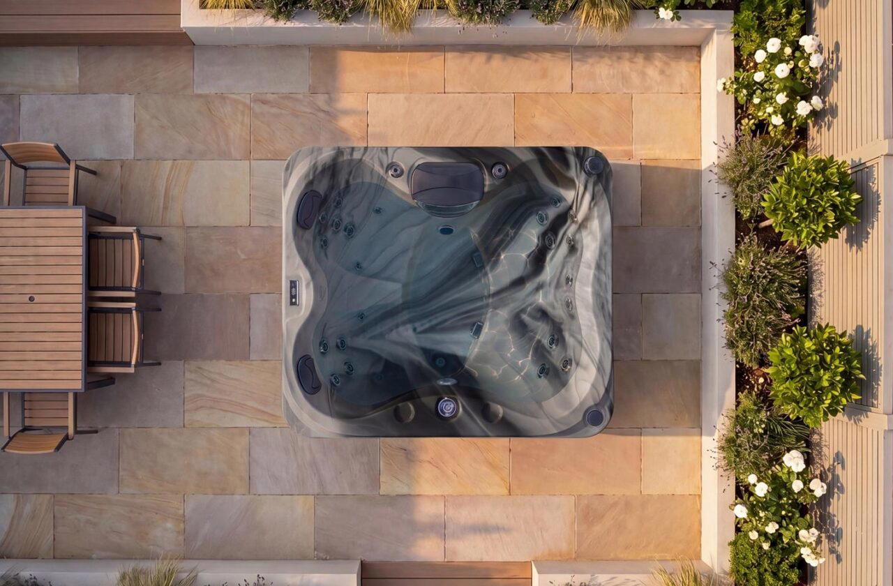 Platinum Spas St. Lucia hot tub in Odyssey acrylic, overhead view on a stone patio at dusk